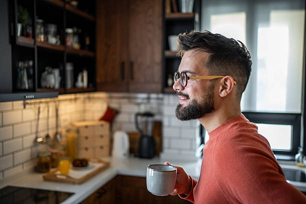 istock Young man enjoying a cup of coffee in his modern kitchen 2216032578