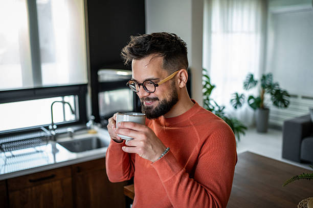istock Young man enjoying a cup of coffee in his modern kitchen 2216032602