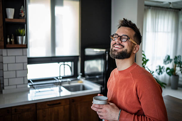 istock Young man enjoying a cup of coffee in his modern kitchen 2216032603