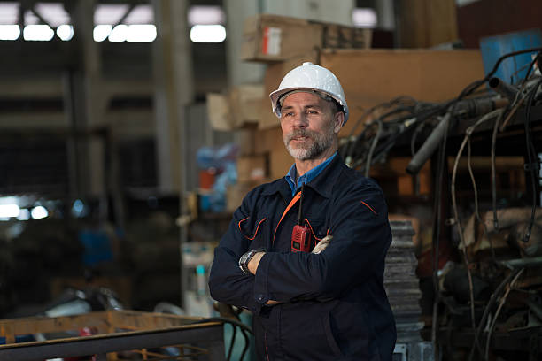 istock Worker, engineer, factory or storage warehouse. Portrait of senior engineer standing with crossed arms in industry factory, inspection of machine for manufacturing, controlling factory operation 2216033512