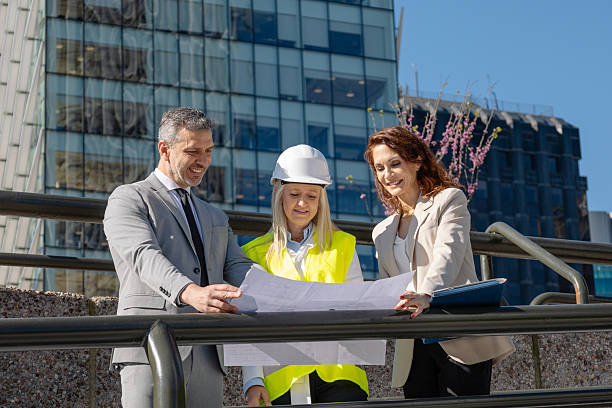 istock Architects and engineers examining blueprint in front of modern building 2216033733