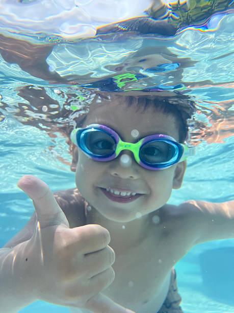 istock Child smiles underwater in a pool 2216034262