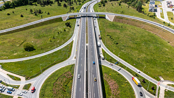 istock Aerial highway interchange with loop ramps and green landscape showing efficient traffic layout and transportation design 2216035099