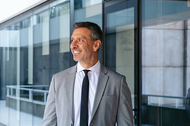 istock Professional man in a suit smiling outside a contemporary office 2216036199