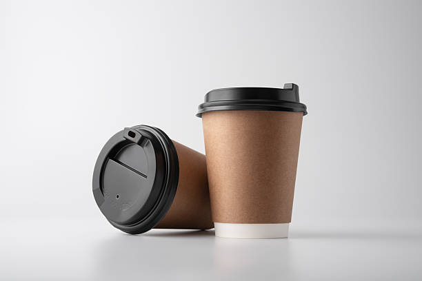 istock Two kraft paper coffee cups with black lids on gray background 2216037449