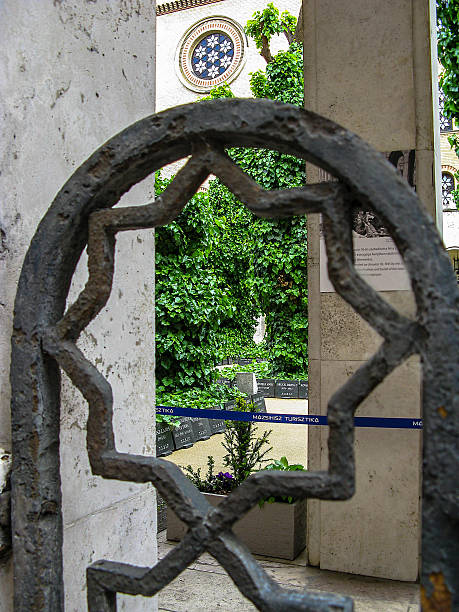 istock Great Synagogue. View of the courtyard with memorial tablets through an old patterned fence. Green vegetation. BUDAPEST. HUNGARY. 2216037498