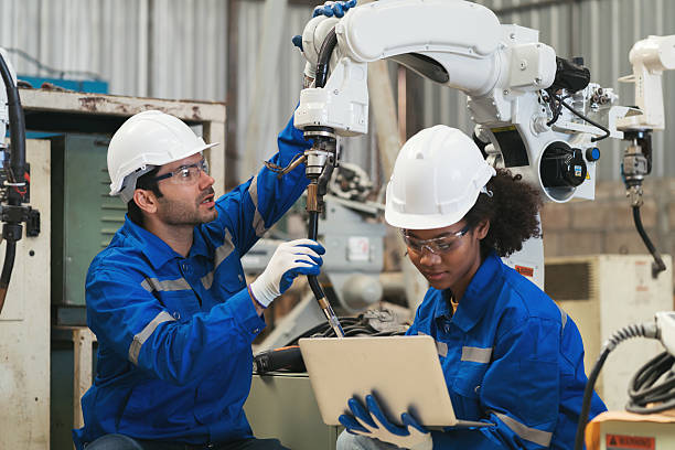 istock Team of engineer worker control automatic robotic arm in factory. Technician worker inspecting quality automatic welding robot arm machine at production line 2216043504
