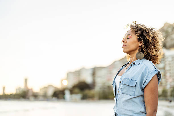 istock Serene Woman Relaxing Outdoors in an Urban Setting During Sunset 2216043615