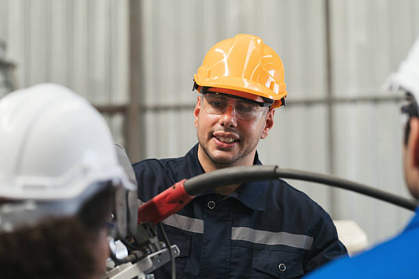 istock Team of male engineer worker control automatic robotic arm in factory. Male technician worker inspecting quality automatic welding robot arm machine at production line 2216044039