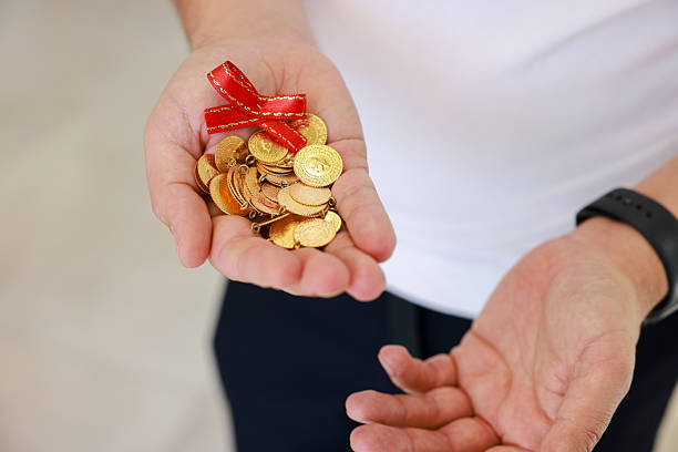 istock Man hand holding 1/4 turkish gold 2216044422