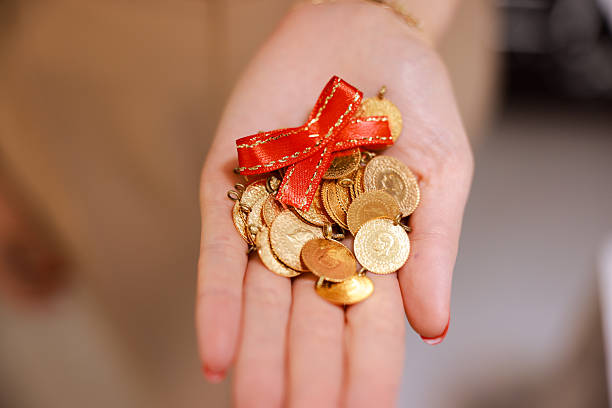 istock Woman hand holding 1/4 turkish gold 2216045795