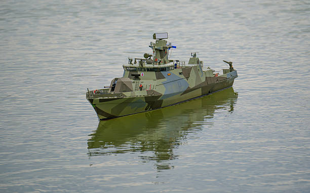 Toy Warship swimming on pond, symmetrical reflections in water
