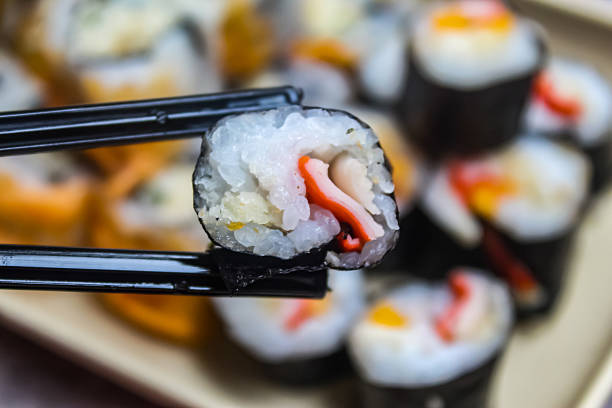 close up of sushi with chopsticks