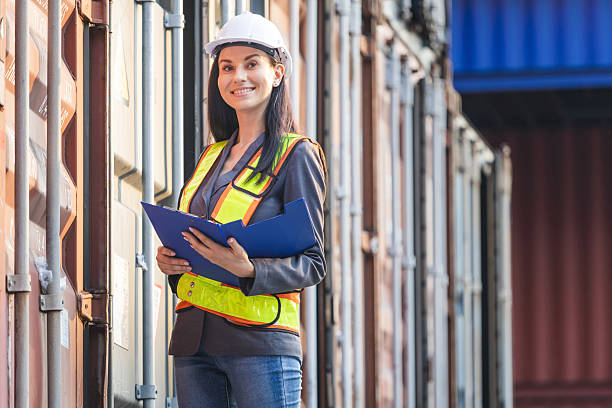 istock Smiling Caucasian Female Engineer in Industry Containers Cargo, Logistics Professional Inspecting Containers Box at Shipping Container Yard 2216048436