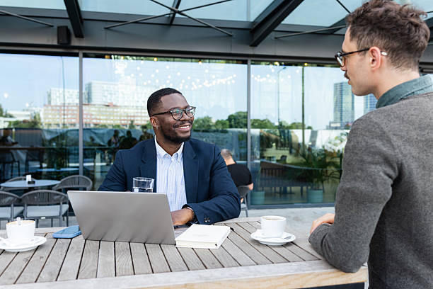istock Colleagues collaborating outdoors over coffee and a laptop at a cafe 2216048747