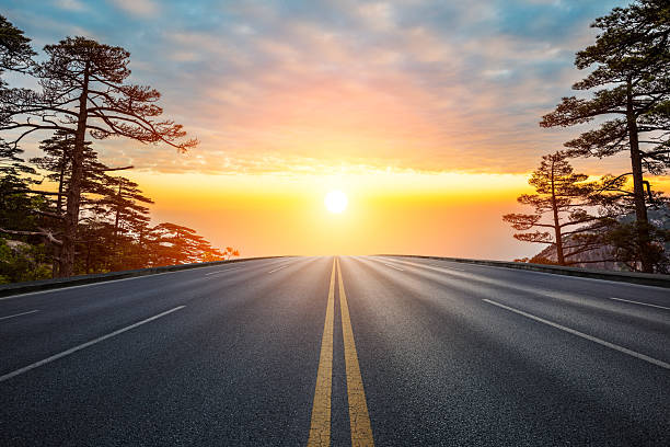 istock Empty asphalt road and pine trees with beautiful sky clouds at sunset 2216050209