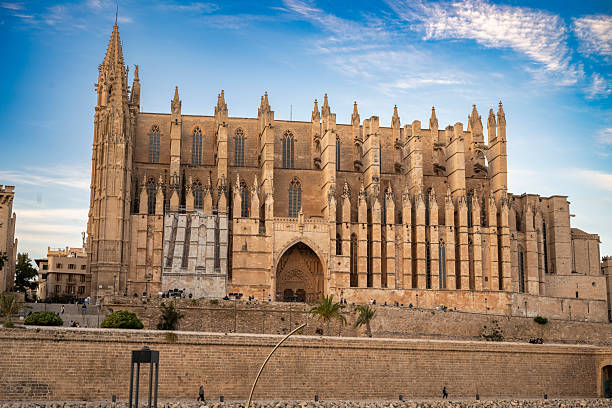 As dusk settles, La Seu reflects its grandeur beside the tranquil water, inviting calm and quiet admiration.