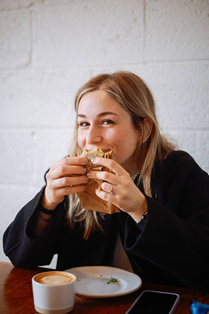 Woman holding a piece of whole wheat sandwich
