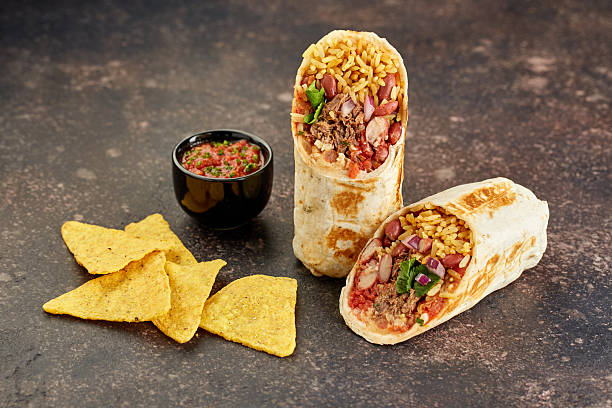 Traditional Mexican Beef Burrito with Nachos Chips and Salsa Sauce.