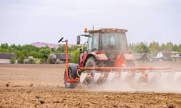istock The tractor is used to sow seeds in the field using a specialized device. The tractor is a powerful tool for agricultural work, equipped with seed planters to prepare the soil for planting. 2216054530