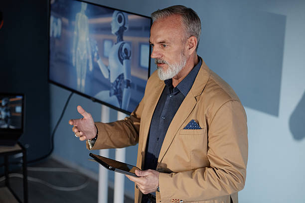 istock Senior Male Speaker Leading Talk on Using AI in Business in Auditorium 2216054651