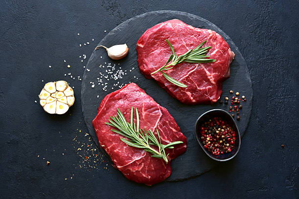 istock Raw organic marbled beef steak with ingredients for cooking . Top view with copy space. 2216055556