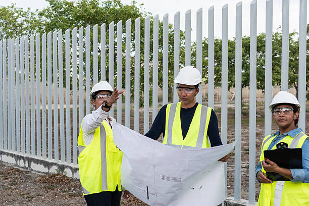 Three female engineers reviewing blueprints on a construction site, discussing next steps