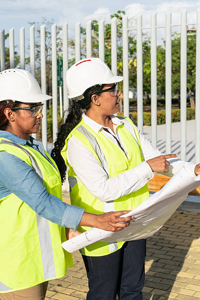 istock Female engineers examining blueprint on construction site 2216056652