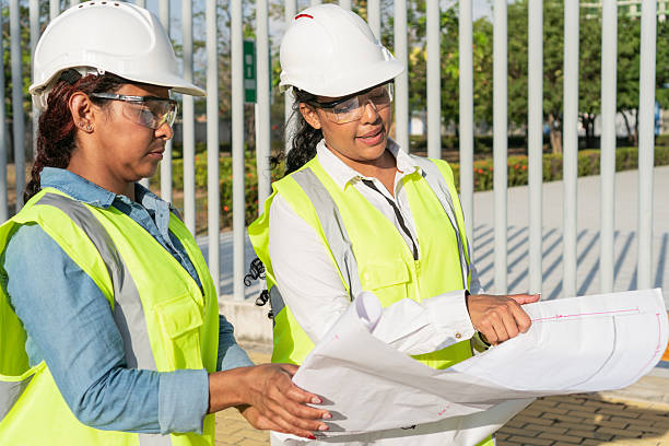 istock Female engineers examining blueprint on construction site 2216056656