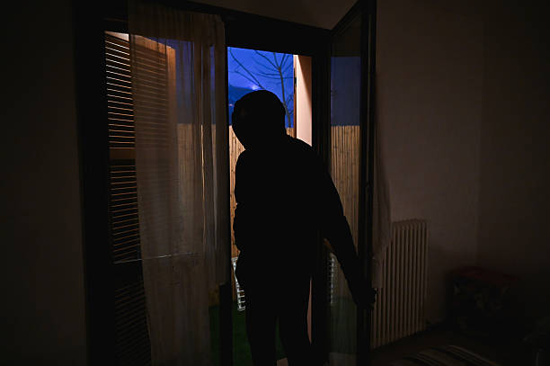 istock Masked burglar sneaking into a house at night 2216057773