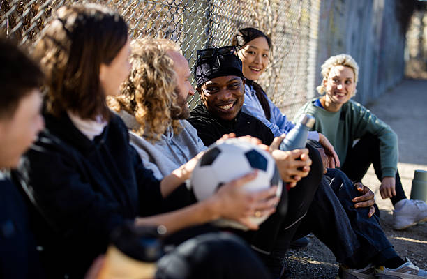 istock Multiracial friends relax with soccer ball after game 2216057992
