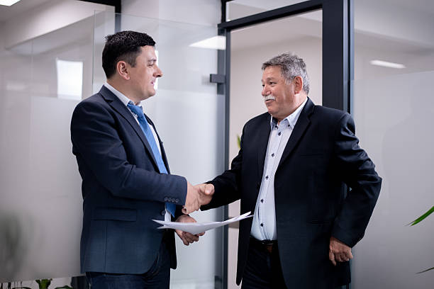 istock Two business professionals shaking hands in a modern office setting during a meeting 2216058581