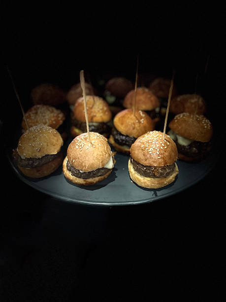 istock mini cheeseburgers on a black background. 2216060648