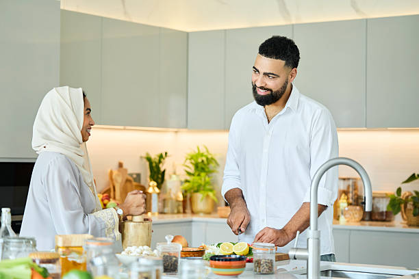 istock Smiling man cutting vegetables and talking with wife 2216062788