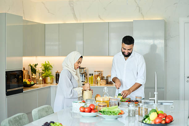 istock Husband and wife helping each other in kitchen 2216062790