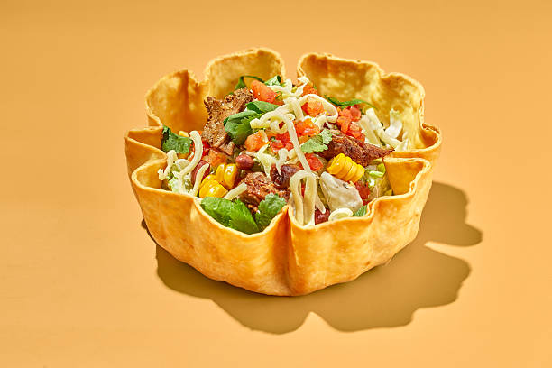 Taco salad in tortilla bowl with beef, cheese, corn and lettuce.