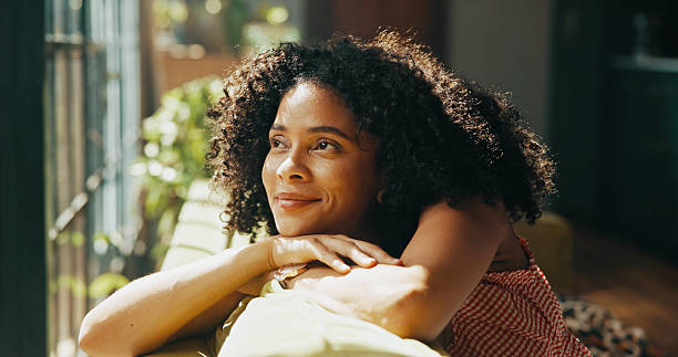 istock Thinking, daydreaming and woman relaxing in home on weekend with memory, self reflection or gratitude. Happy, calm and female person with decision, choice or peaceful morning on sofa in apartment. 2216065995
