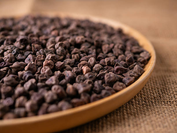 istock Raw Dark Brown Chickpeas (Kala Chana) on a rustic wooden table. Dry Balck chickpea (ceci neri) background close up. 2216066222