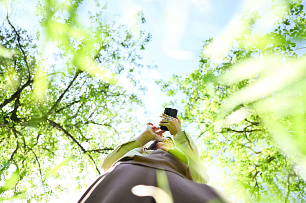 istock Woman using smartphone in green lush forest 2216070326