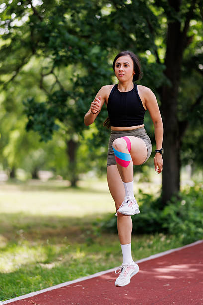 istock Athletic Woman Practicing Exercises Outdoors With Tape Support on Sunny Day 2216072293