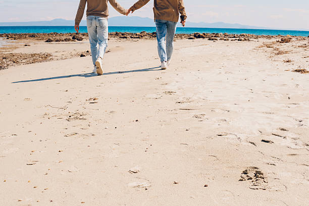 Happy couple walking on the beach. They enjoy in beauty spring day on the sea.
