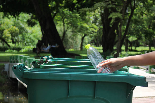 istock Recycling.Woman hand throwing bottle water into trash can 2216077768