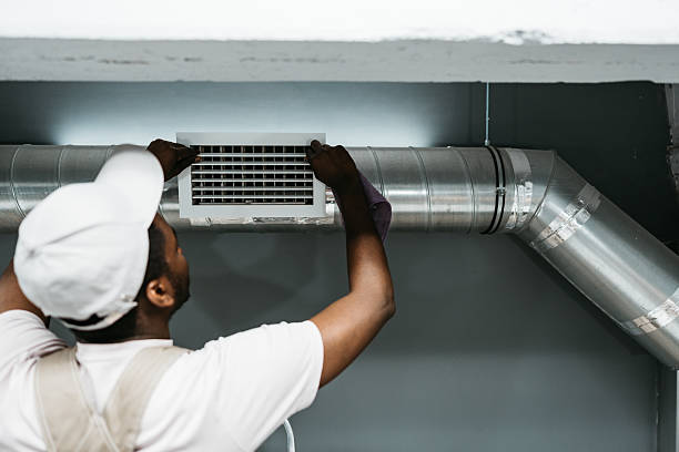 istock Technician performs air duct installation in a residential building during daylight hours 2216079780