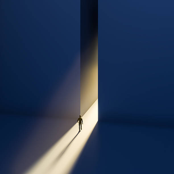 istock A man walking to a gap in the wall with light spilling out. Concept for positivity, getting out of a depression, the way forward. 2216079977
