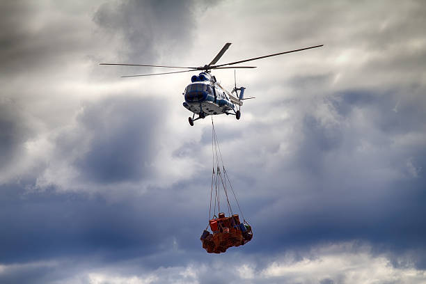 istock Helicopter carries sling (rope mesh) with empty metal barrels 2216080073