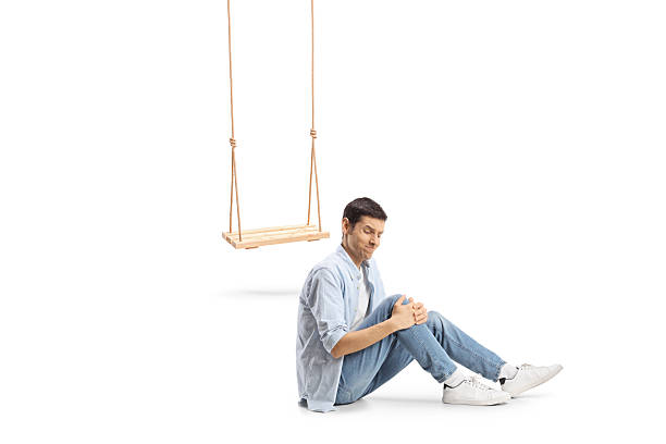Man falling from a wooden swing and injuring knee isolated on white background