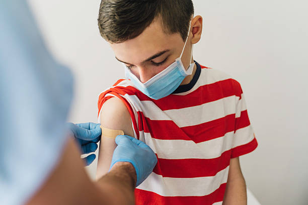 istock Vaccination Process: Band-Aid on Young Boy's Arm 2216084620