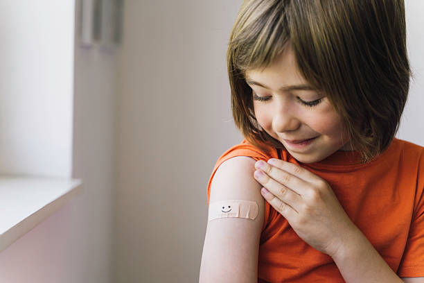 istock Young Boy Admiring Her Vaccination Band-Aid 2216084627