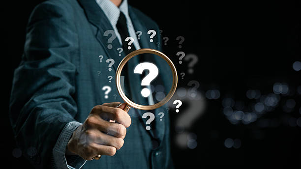 istock A hand holding a magnifying glass over large question marks surrounded by smaller ones symbolizes cause analysis and problem-solving. Question mark and root cause analysis concept. solution, analyze 2216085244