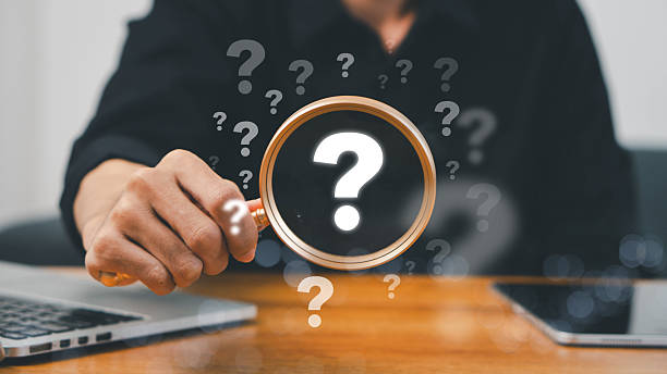 istock A hand holding a magnifying glass over large question marks surrounded by smaller ones symbolizes cause analysis and problem-solving. Question mark and root cause analysis concept. solution, analyze 2216085245